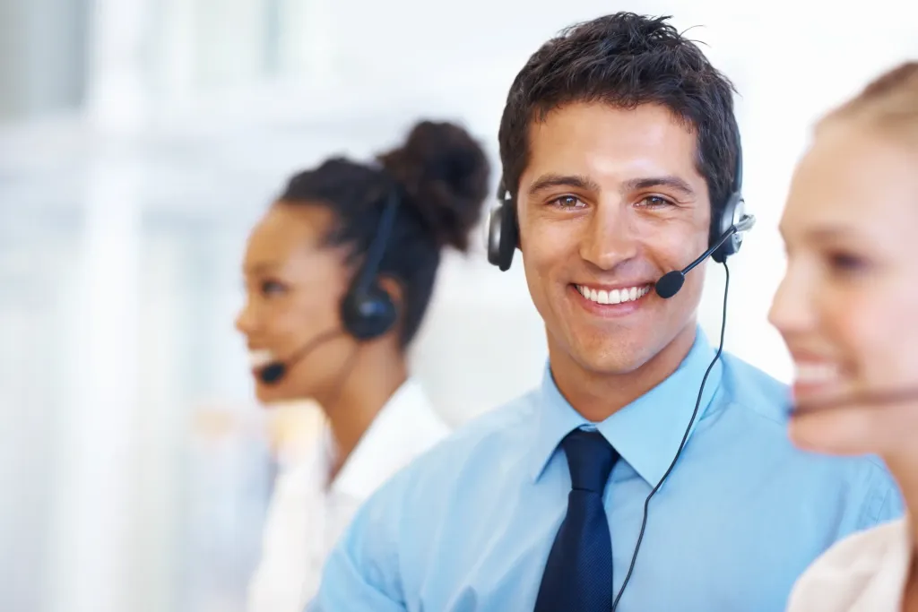 Mosolygó ügyfélszolgálati munkatársak headsettel, telefonos segítség közben